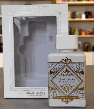 BADEE AL OUD HONOR & GLORY, perfume en frasco cuadrado plateado con detalles geométricos dorados y caja a juego.