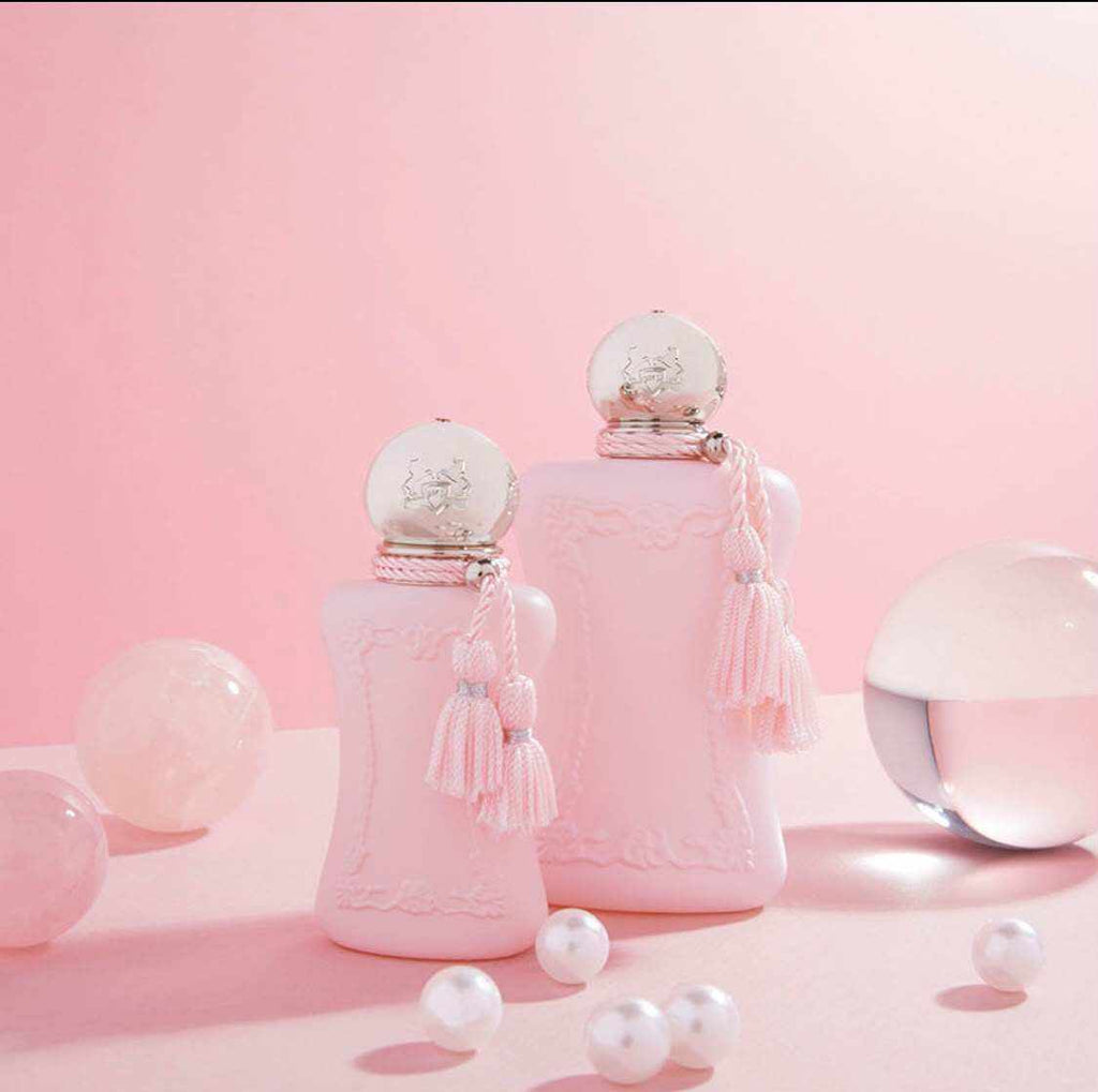 Delina Eau de Parfum en frascos rosa pálido de vidrio, con tapones decorados y borlas colgantes