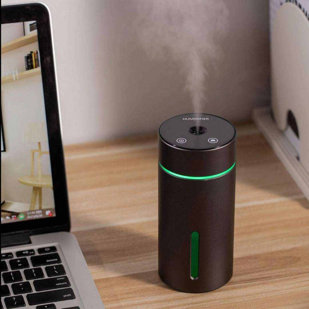 Humidificador portátil para coche negro cilíndrico, con acabado metálico, franja luminosa verde y controles en la parte superior