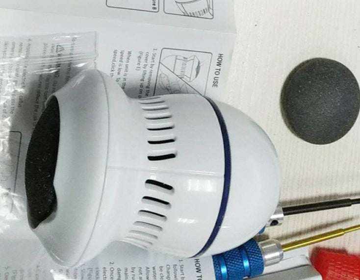Lima eléctrica para pies blanca de plástico, con cuerpo cilíndrico ventilado y cabezal abrasivo negro extraíble.