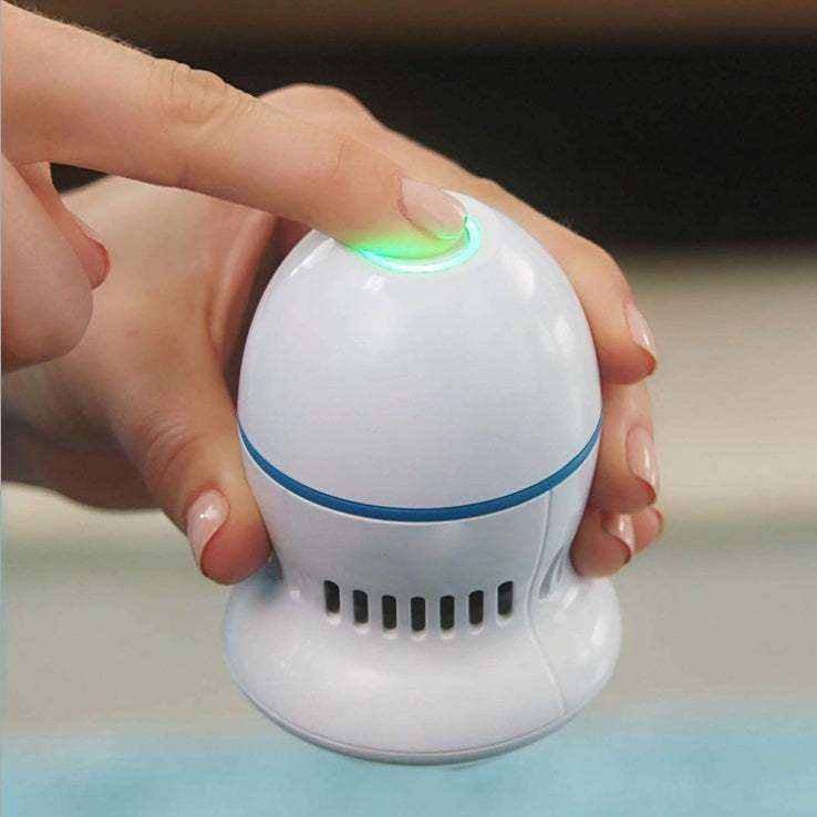 Lima eléctrica para pies blanca de plástico con aro azul, botón luminoso verde y ranuras de aspiración.